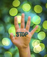 AI generated A hand with the text STOP against bokeh background. Stop polluted earth concept, Earth day. photo