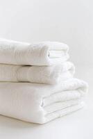 AI generated Simple Stack of Crisp, Folded White Towels Against a Pure White Background. photo