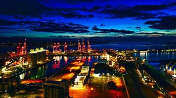 Panoramic night view of a bustling port with illuminated cranes and buildings, reflecting on the water in Liverpool, UK. photo