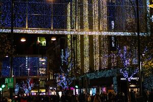 City street adorned with twinkling blue holiday lights at night, creating a festive atmosphere. photo