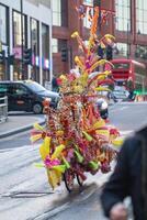Colorful street performer in vibrant costume walking in urban setting with blurred background. photo