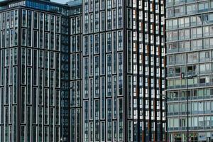 Modern glass office buildings with a pattern of windows reflecting the sky, showcasing urban architecture in Liverpool, UK. photo