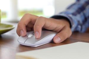 Close up of male hand using wireless keyboard and mouse in office desk. Casual working concept photo