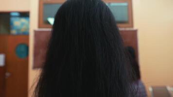 Rear view of students in uniform raising hands in a classroom setting, indicating participation or answering a question. video