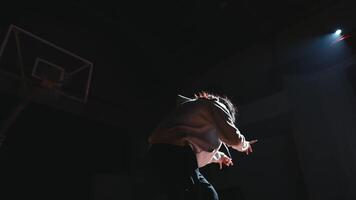 Silhouette von ein Person auf Bühne mit Scheinwerfer und amerikanisch Flagge im das Hintergrund, vermitteln ein Sinn von Theater und Patriotismus. video