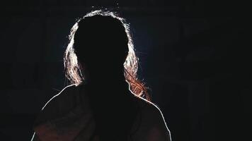 Silhouette of a person against a dark background with rim lighting. video