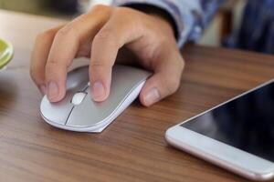 Close up of male hand using wireless keyboard and mouse in office desk. Casual working concept photo