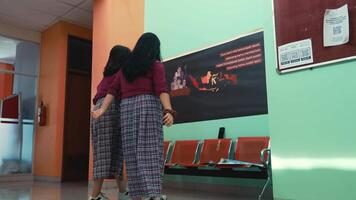 Two students in uniforms watching a presentation in a classroom setting. video