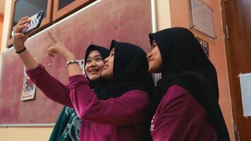 Three women in hijabs taking a selfie with a smartphone. video