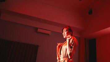 Silhouette of a female dancer performing with expressive gestures on a dark stage with moody lighting. video