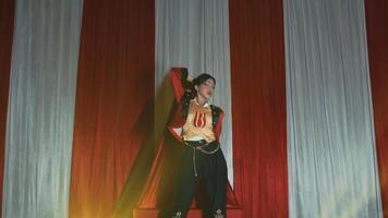 vrouw performer in piraat kostuum het zingen Aan stadium met rood gordijnen in de achtergrond. video