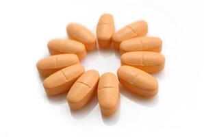 Orange pills on white background photo