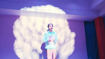 Performer on stage with dramatic lighting and brain projection in the background, depicting a conceptual performance. video