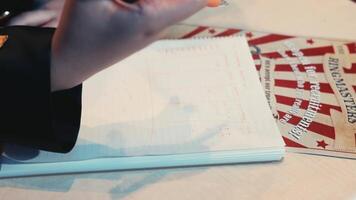 close up woman hand writing notes with audience in background at a seminar or conference setting. video