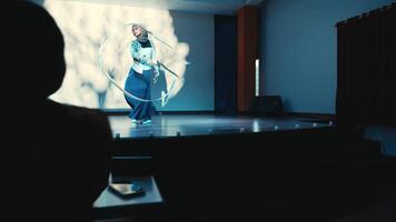 Silhouette of a person watching a movie on a large screen in a dark room. video