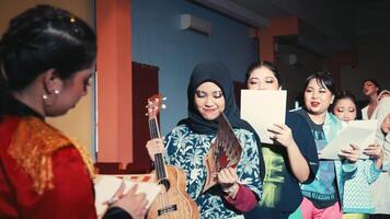 grupo de diverso niños con musical instrumentos y hojas de papel, sonriente y caminando en un teatro pasillo. video