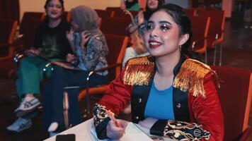 Elegant woman in a decorated jacket at a social event with people in the background. video