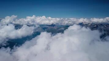 Aerial flight through clouds over mountain landscape. The alps below under the clouds video