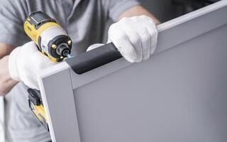 Professional Caucasian Cabinetmaker Contractor with a Drill Driver photo