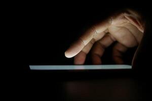 Close up of young man hand using smart phone at night photo