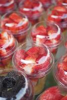 Ripe Red Strawberries in. plastic container selling at shop photo