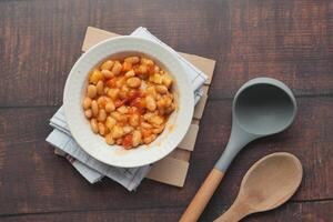 Tasty baked beans in a bowl on table photo