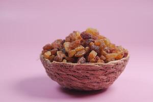 raisin on a bowl on color background photo