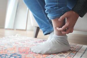 man suffering from itching skin on his feet photo