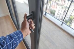 hand open gray plastic pvc window at home at early morning photo