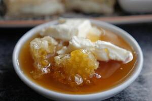 butter cream and honey in a bowl on table . photo