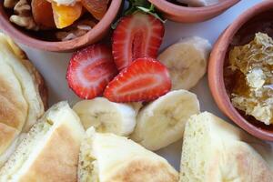 Close up of fresh banana. strawberry and nuts on a plate photo