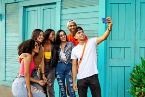 grande grupo de alegre joven amigos tomando selfie retrato. contento personas mirando a el cámara sonriente. concepto de comunidad, juventud estilo de vida y amistad. foto