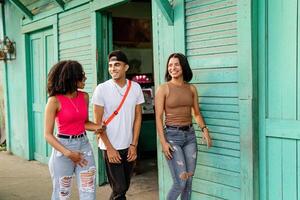 Tres latín americano amigos caminando en vecindario. foto