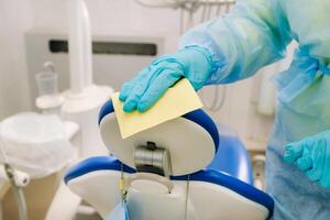 A nurse disinfects work surfaces in the dentist's office. photo