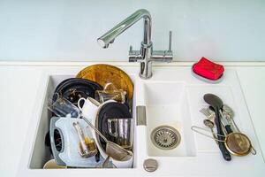 pila de sucio platos en el hundir. platos necesitar Lavado. cocina lavabo con sucio platos. foto