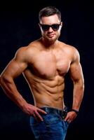 Strong and fit man bodybuilder. Sporty muscular guy athlete. Sport and fitness concept. Men's power. photo