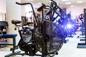 Metal bicycle trainers. Fitness hall with sport bikes. Metal bicycle trainers. Equipment in gym. photo