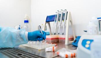 Laboratory assistants analyzing blood sample. Assistance in gloves. Prevention. Pneumonia diagnosing. COVID-19 and coronavirus identification. Pandemic. photo