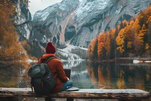 AI generated A man sitting on a rock in the mountains enjoying the scenic view photo