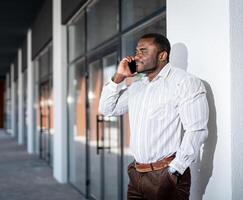 Office manager in white shirt have a phone call. Handsome stylish man in casual clothes on urban street. photo