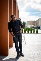 Young confident man in urban city. Handsome businessman in glasses on modern city street. photo