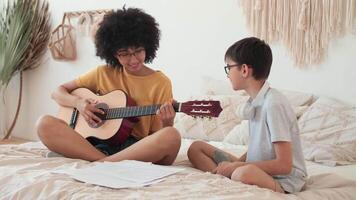 música ensino, musical Educação, jogando guitarra, Tempo junto. engraçado casal jogando guitarra enquanto sentado em cama video