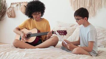 la musique enseignement, musical éducation, en jouant guitare, temps ensemble. femme prof enseignement guitare cours à garçon video