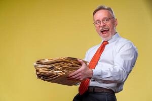 Files in hands of a surprised businessman or manager isolated on yellow background. photo