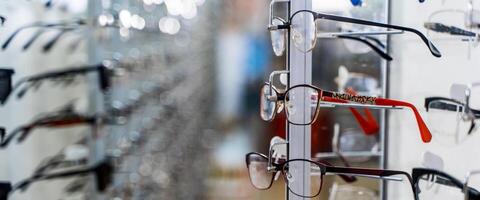 Eye glasses in a store. Eyeglasses shop. Stand with glasses in the store of optics. photo