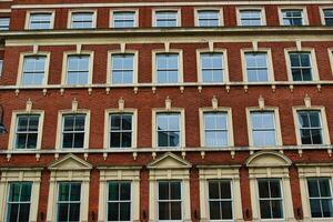 Facade of a classic red brick building with symmetrical windows against a clear sky in Leeds, UK. photo