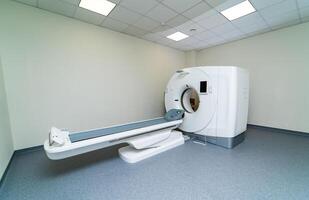 Tomography scanner in hospital ward. Selective focus on MRI table with no patient. Modern MRI equipment in clinic photo