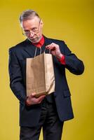 Man holds a paper bag receiving a present. Eco shopping. Man in suit. photo