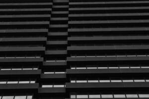 Monochrome image of modern building facade with geometric pattern of windows and ledges, abstract urban background in Leeds, UK. photo