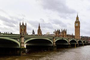 Westminster Bridge and the iconic Big Ben on a cloudy day in London, UK. photo